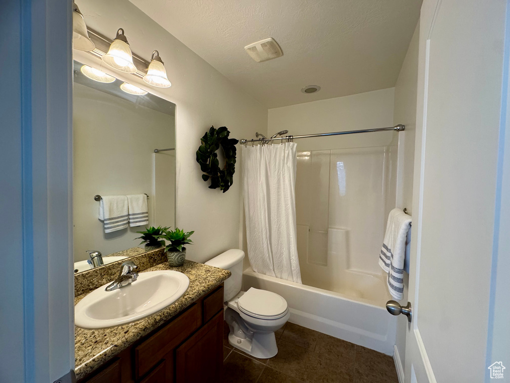 Bathroom with shower / tub combo with curtain, toilet, vanity, and tile patterned floors