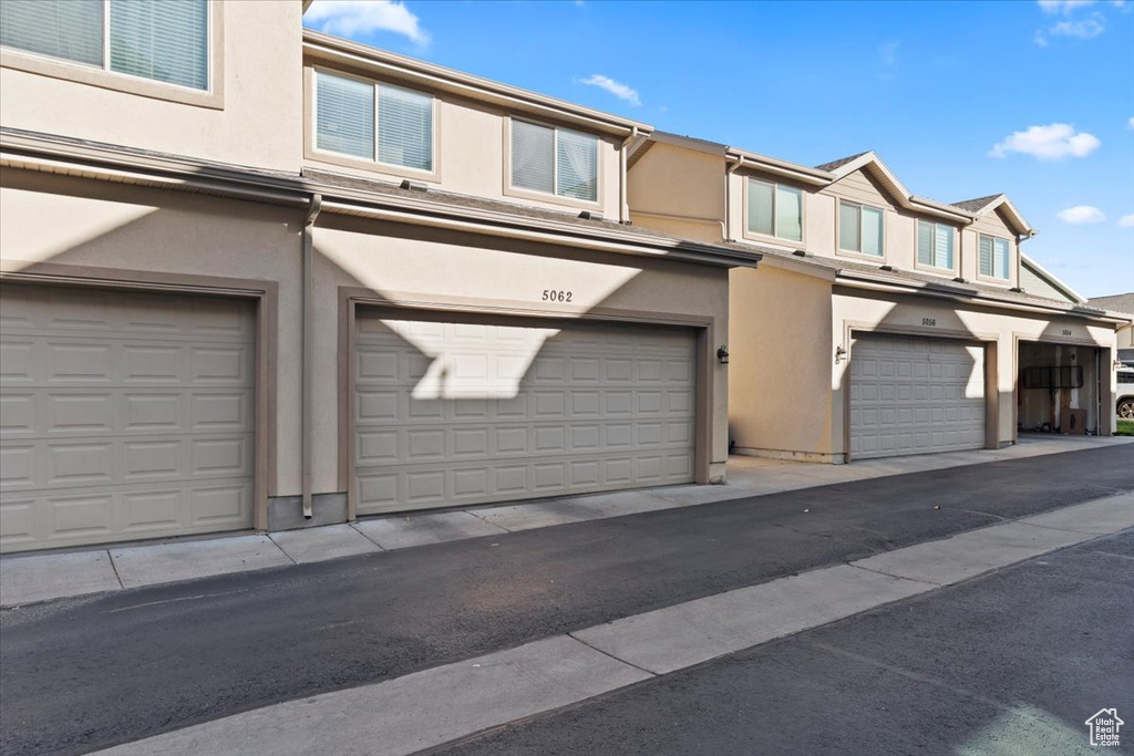 View of front of home featuring stucco siding and a garage