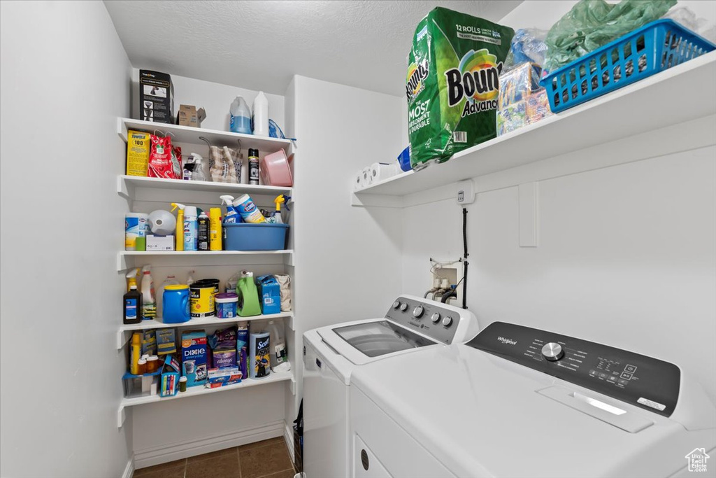 Laundry room featuring washer and clothes dryer and tile patterned flooring