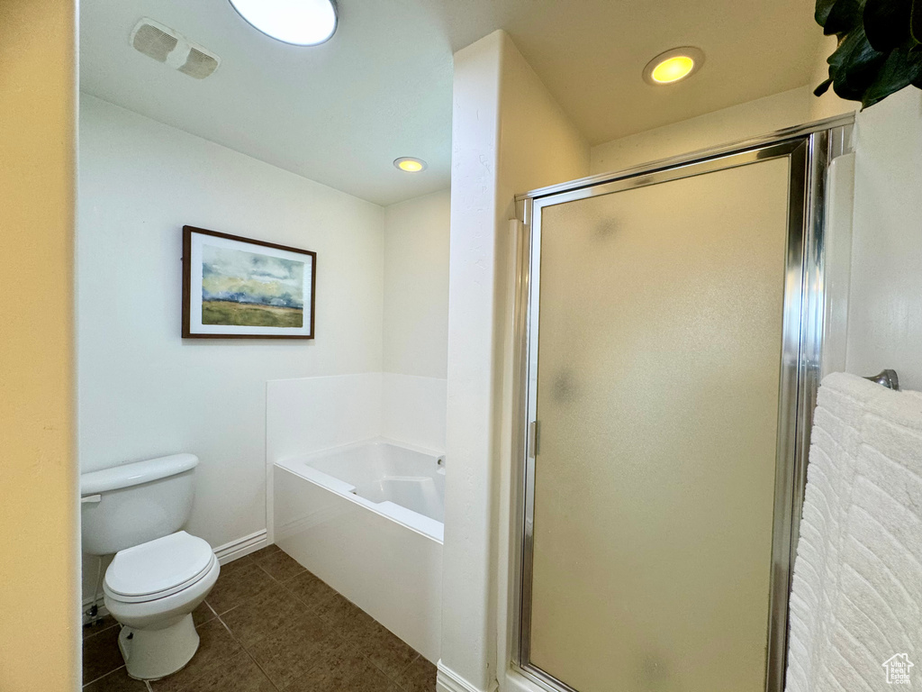 Bathroom with toilet, a garden tub, a shower stall, tile patterned flooring, and baseboards