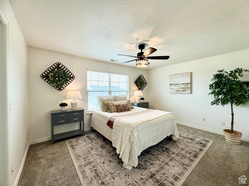 Bedroom with light carpet, baseboards, and a ceiling fan