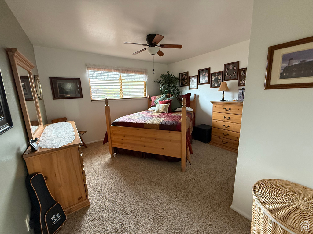 Carpeted bedroom featuring a ceiling fan and baseboards