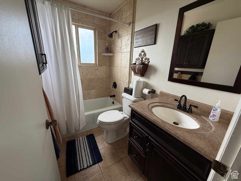 Full bathroom featuring shower / bath combo with shower curtain, vanity, toilet, and tile patterned flooring