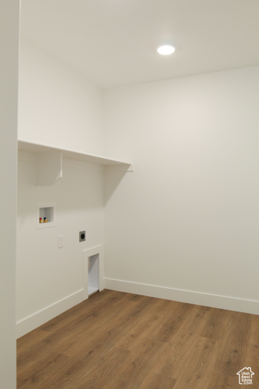 Laundry room featuring baseboards, washer hookup, wood finished floors, hookup for an electric dryer, and recessed lighting