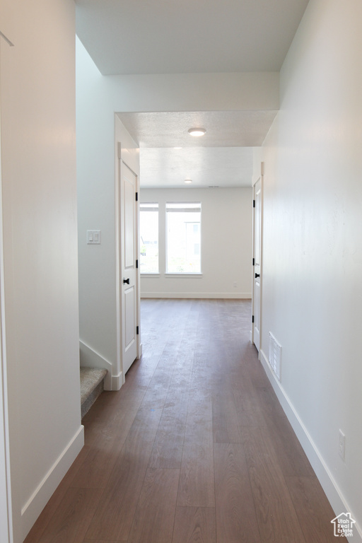 Hall with wood finished floors and stairs
