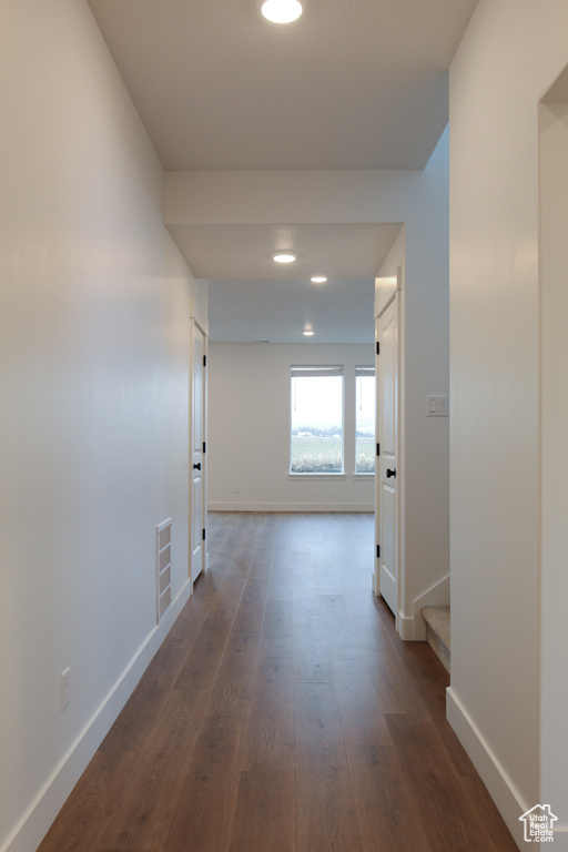 Corridor with baseboards, dark wood-style floors, stairs, and recessed lighting