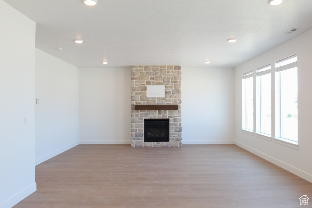 Unfurnished living room with recessed lighting, light wood finished floors, and a fireplace
