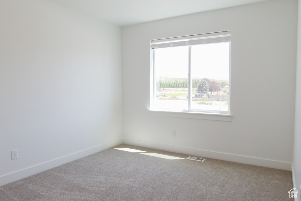 Carpeted spare room with baseboards