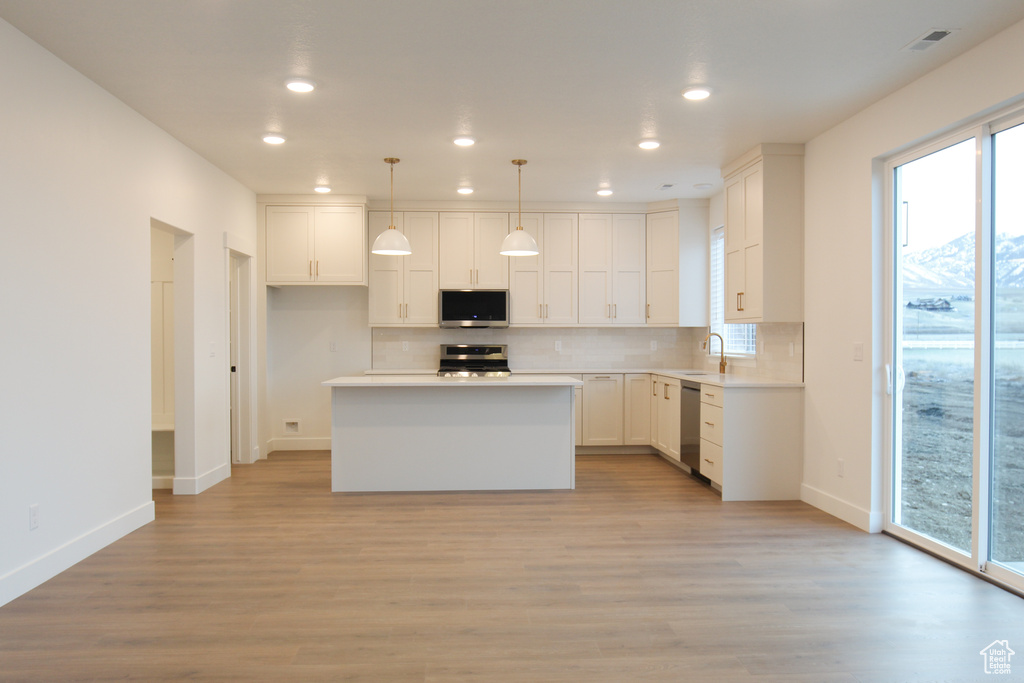Kitchen featuring stainless steel appliances, backsplash, baseboards, recessed lighting, and a sink