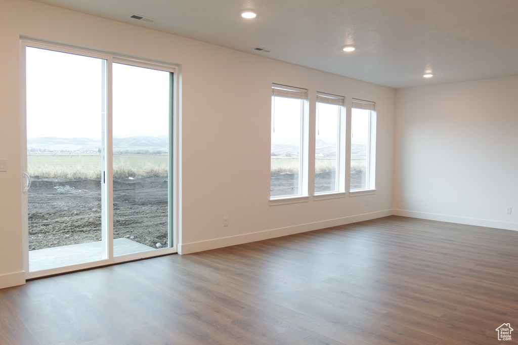 Unfurnished room with dark wood-style flooring, baseboards, and recessed lighting