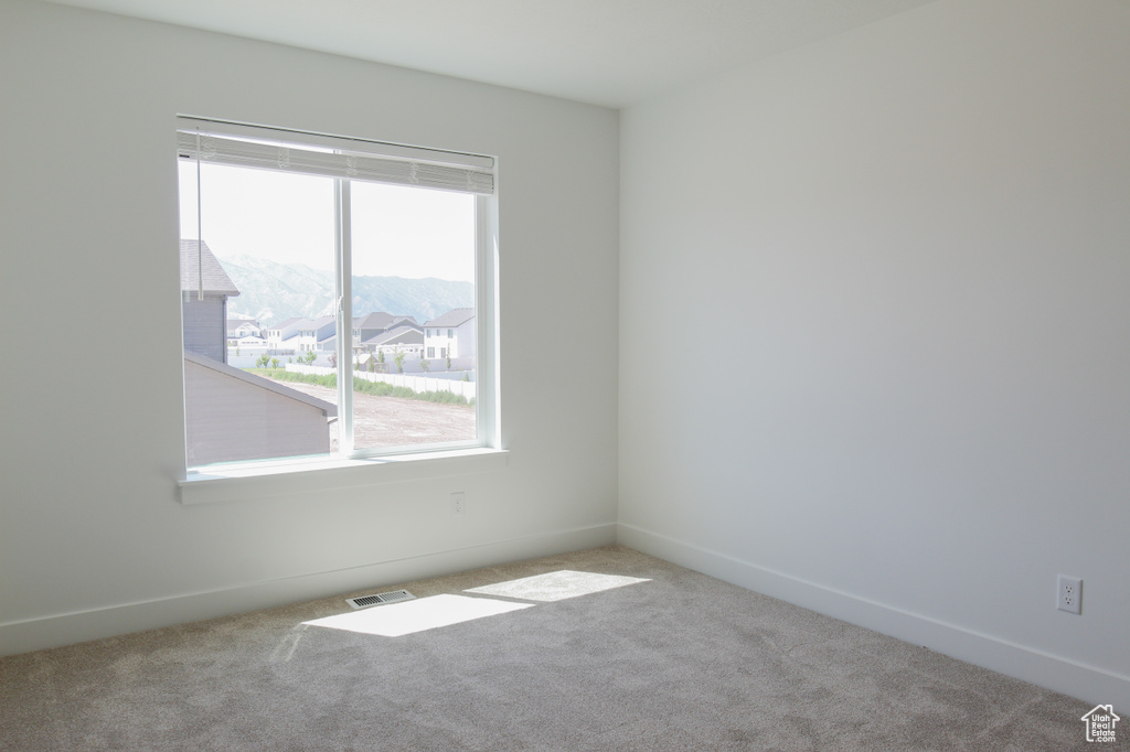 Carpeted empty room with baseboards
