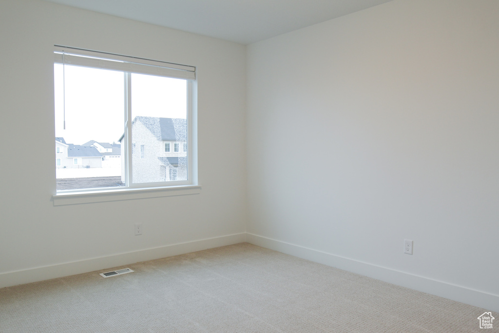 Carpeted empty room featuring baseboards