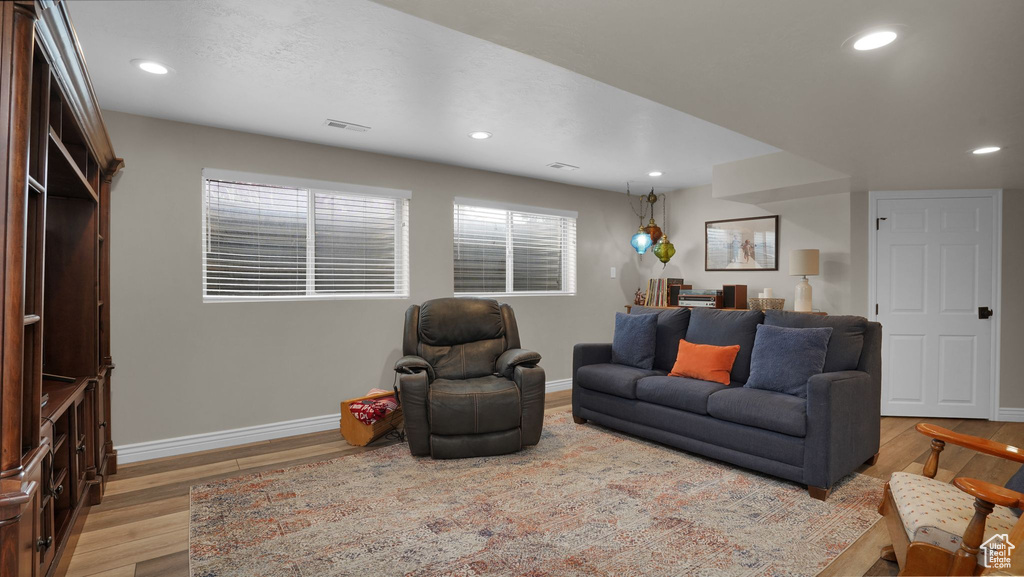 Living area with baseboards, wood finished floors, and recessed lighting