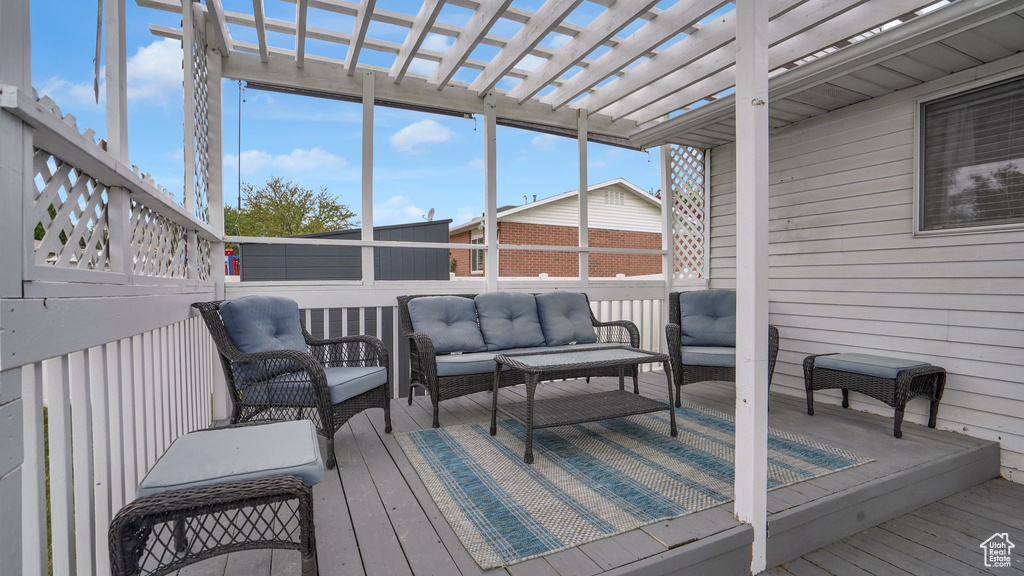 Wooden terrace with an outdoor living space and a pergola