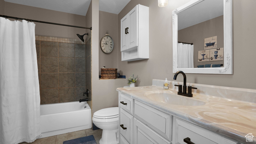 Full bath featuring toilet, tile patterned flooring, vanity, and shower / bath combination with curtain