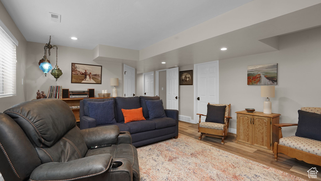 Living room with wood finished floors, recessed lighting, and baseboards