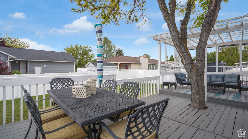 Deck featuring outdoor lounge area, a fenced backyard, a pergola, and outdoor dining area