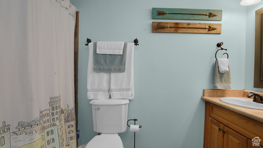 Bathroom featuring vanity, toilet, and a shower with shower curtain