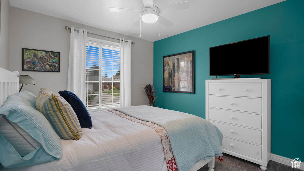 Carpeted bedroom with ceiling fan and baseboards