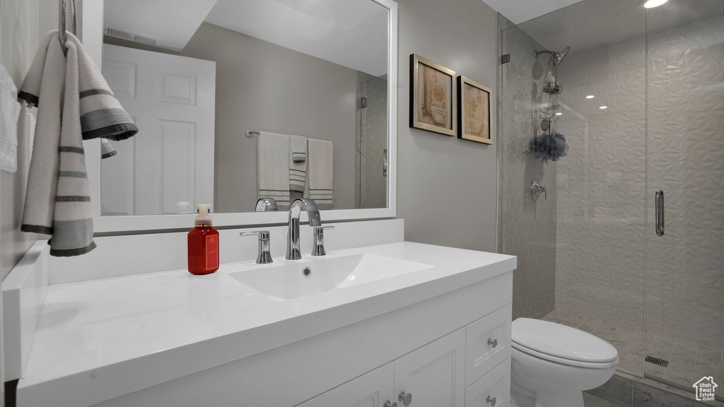Full bath with a stall shower, toilet, and vanity