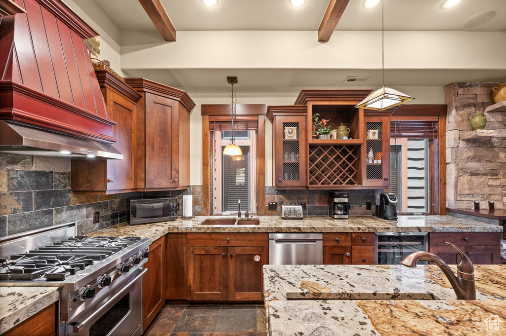 Kitchen featuring appliances with stainless steel finishes, custom exhaust hood, beamed ceiling, backsplash, and hanging light fixtures