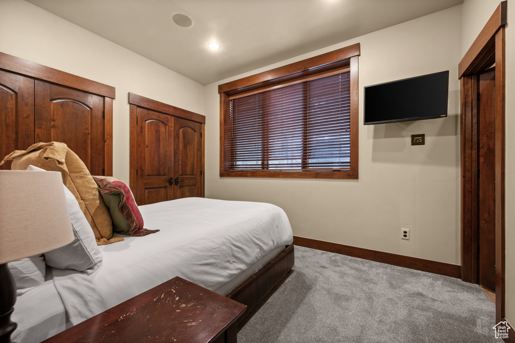 Carpeted bedroom with two closets and recessed lighting