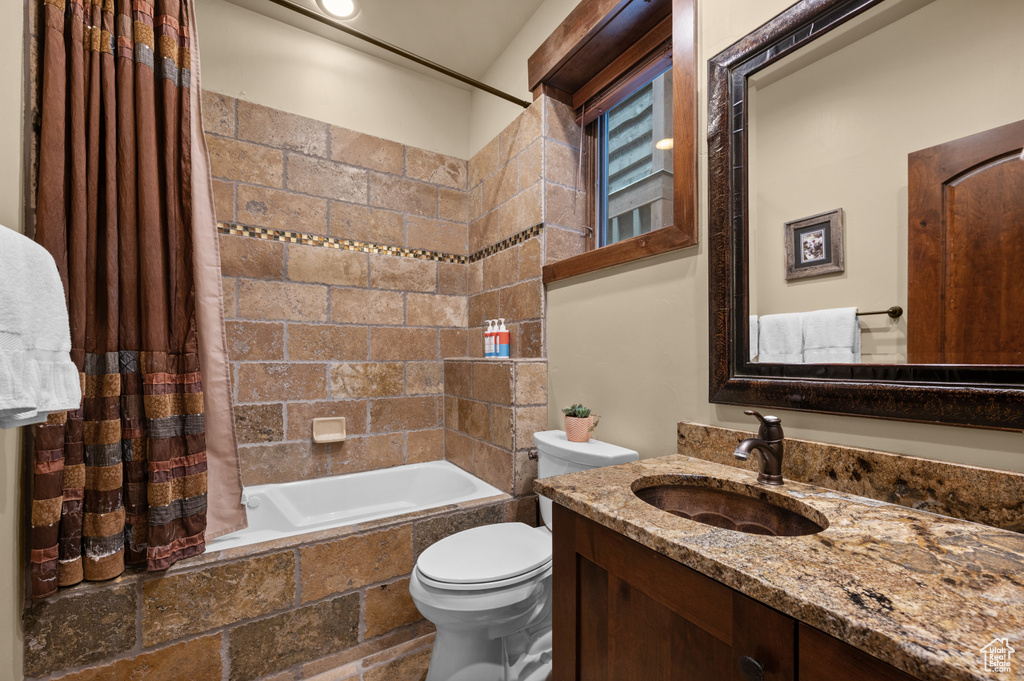 Full bath with tiled shower / bath combo and vanity
