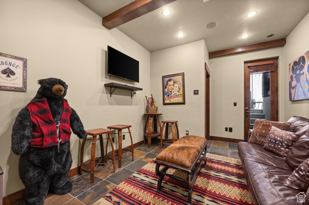 Living area with stone tile flooring, recessed lighting, and beamed ceiling