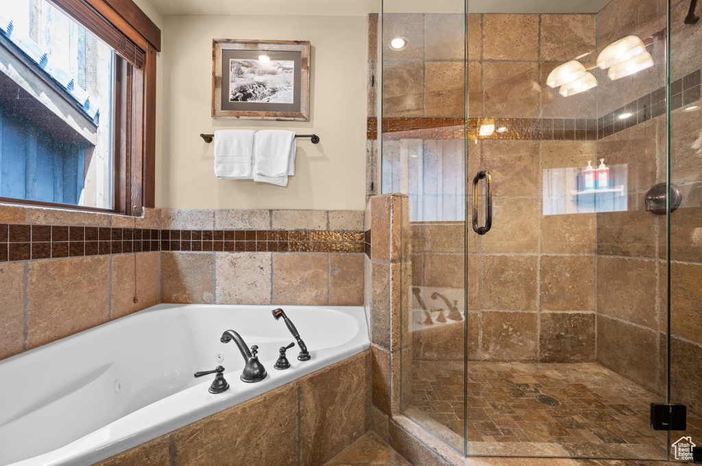 Full bath with a tub with jets and a shower stall
