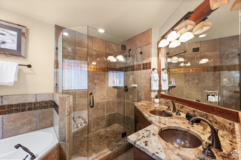 Bathroom with double vanity, a garden tub, and a stall shower