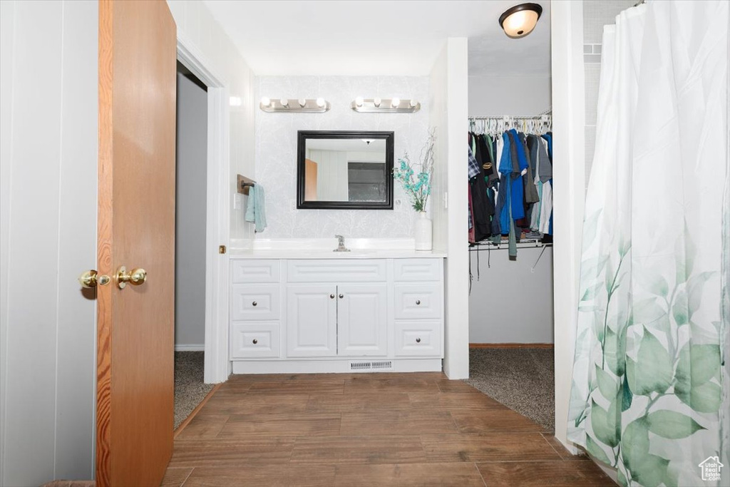 Bathroom with vanity, baseboards, and a shower with shower curtain