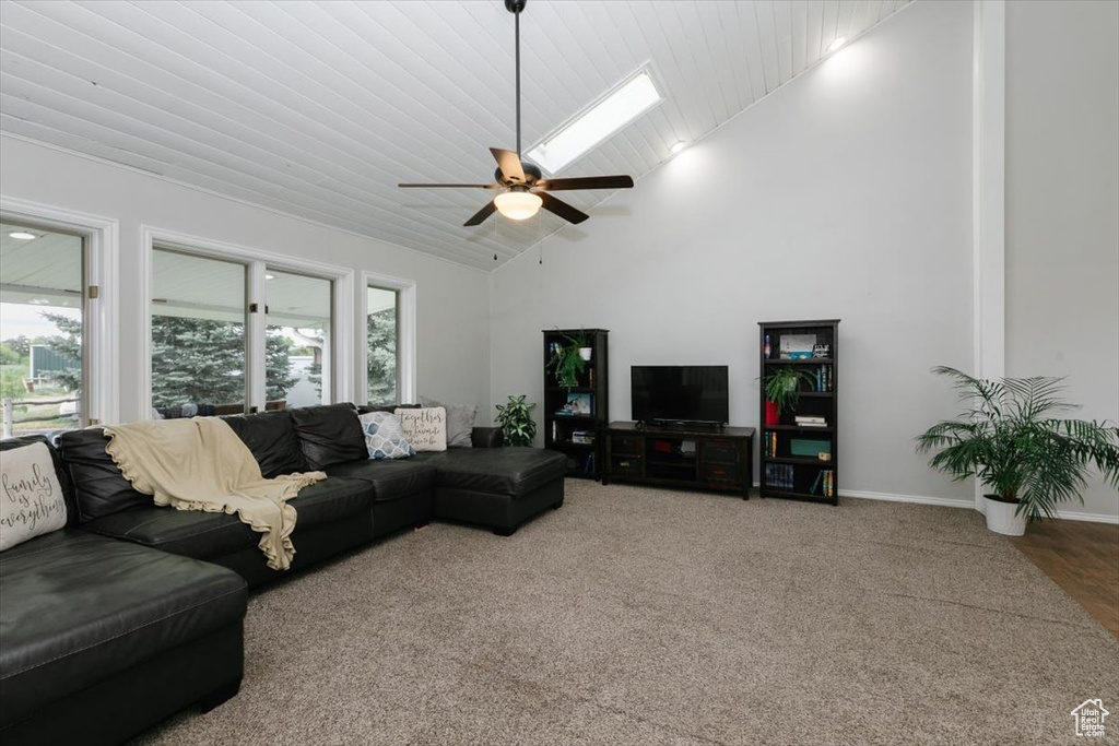 Carpeted living area featuring high vaulted ceiling, ceiling fan, baseboards, and wood ceiling