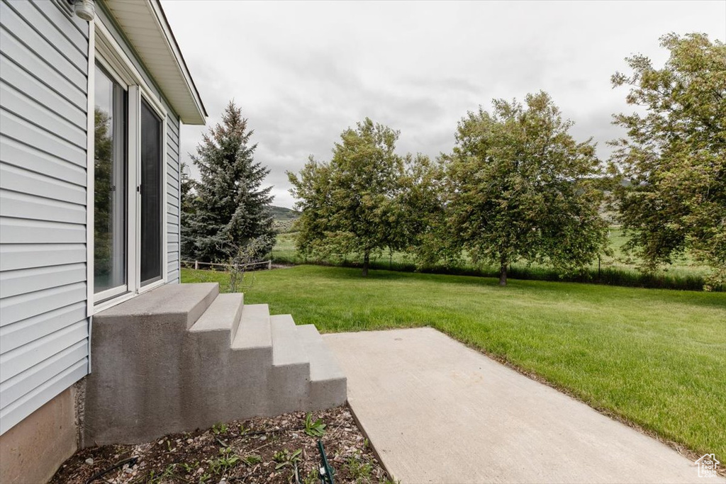 View of grassy yard with a patio