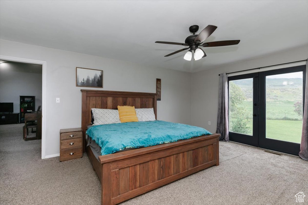 Bedroom with light colored carpet, access to outside, ceiling fan, french doors, and baseboards