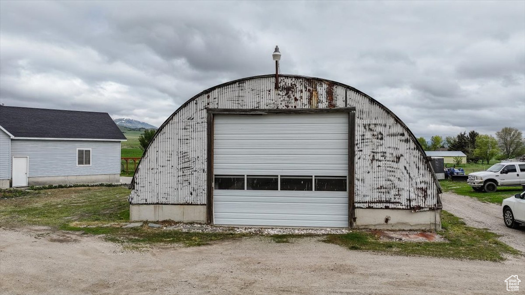 Detached garage featuring dirt driveway