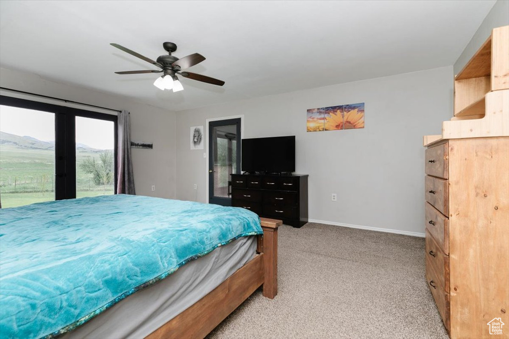 Bedroom featuring light carpet, access to outside, baseboards, and ceiling fan