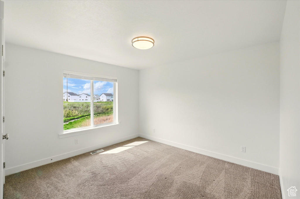 Carpeted empty room with baseboards
