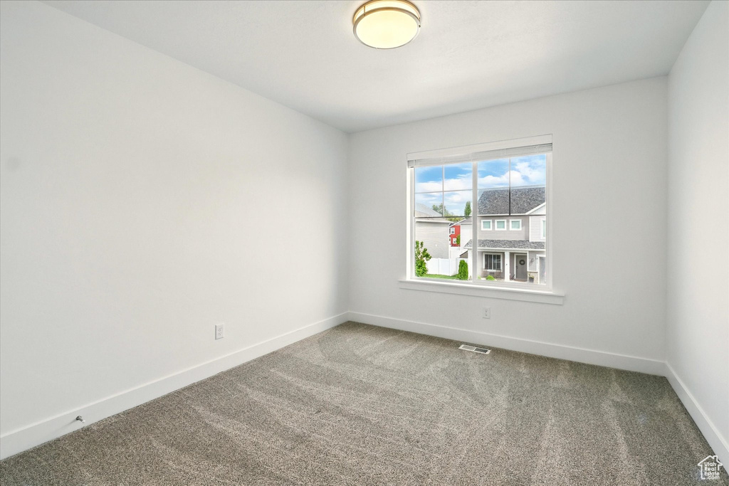 Empty room with carpet flooring and baseboards
