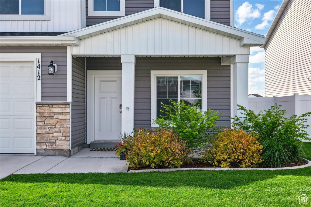 View of exterior entry featuring a garage and stone siding