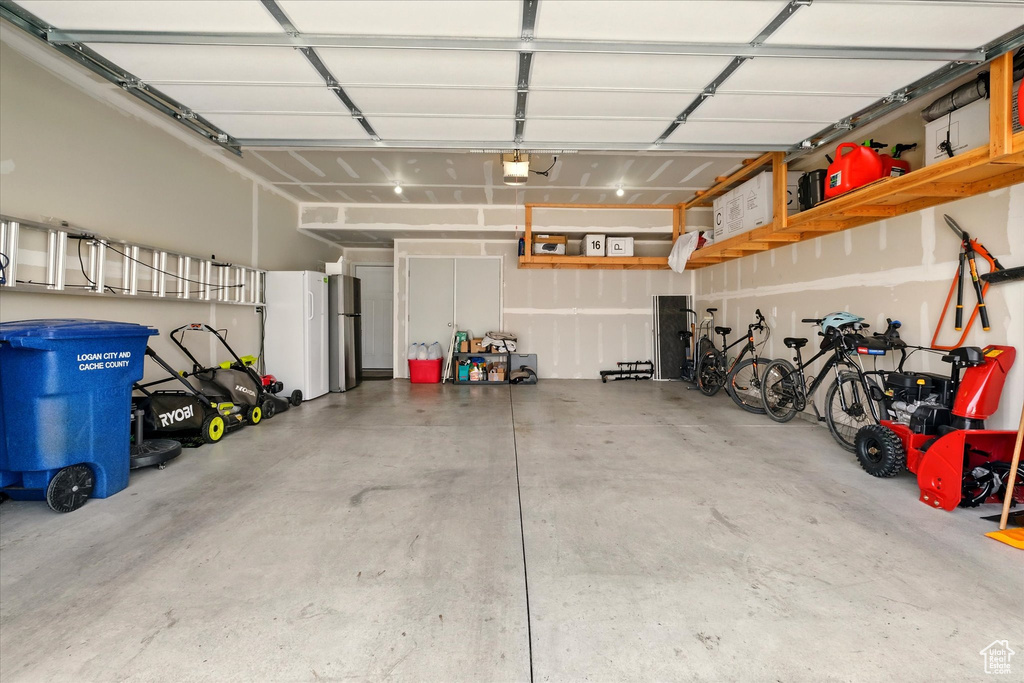Garage with a garage door opener and freestanding refrigerator