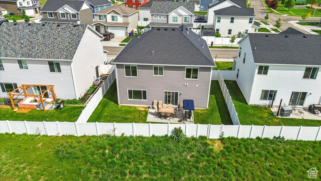 Rear view of property featuring a residential view, a patio, and a shingled roof