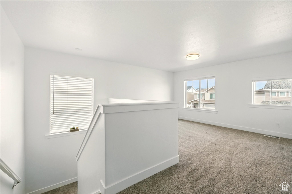 Spare room with baseboards and light carpet