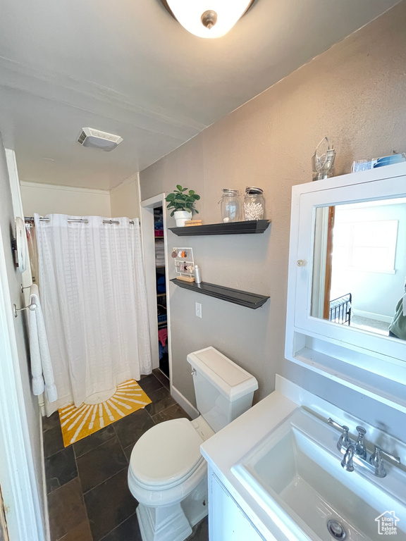 Full bath featuring a shower with curtain, vanity, toilet, and tile patterned flooring