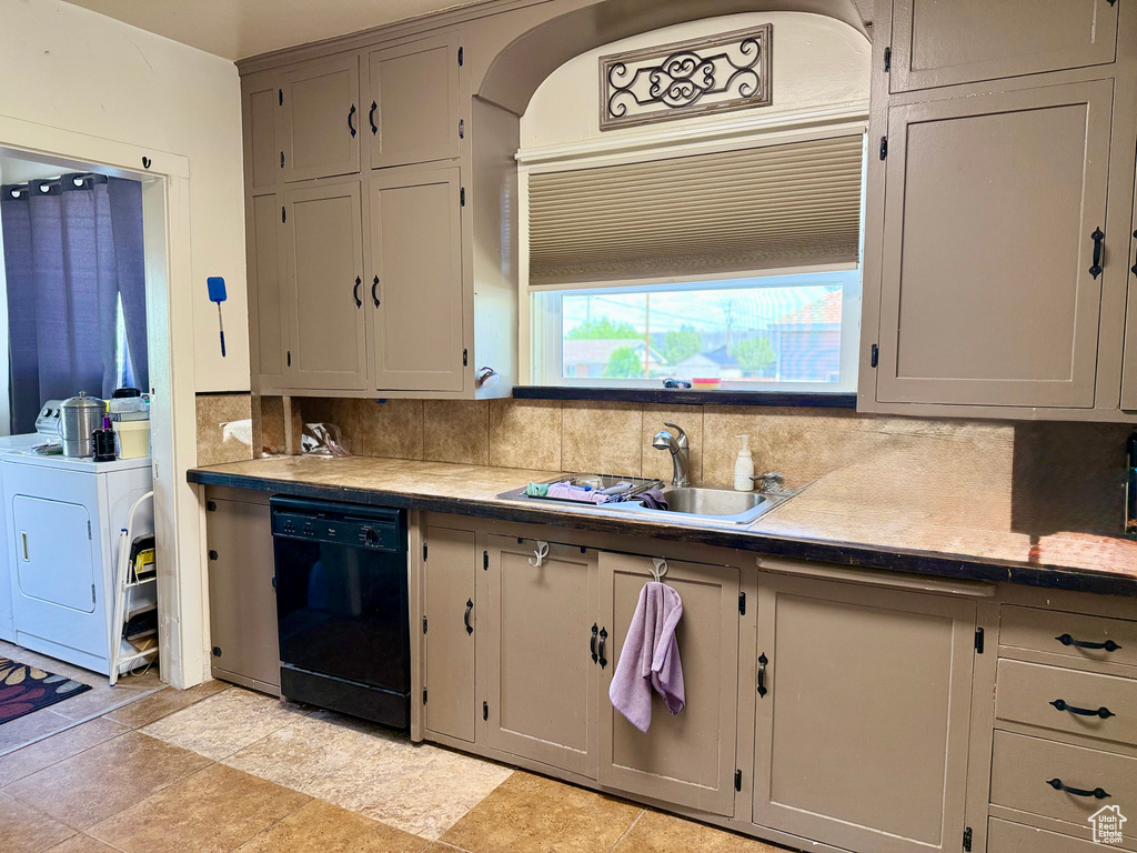 Kitchen with dishwasher, a sink, washer / clothes dryer, tasteful backsplash, and gray cabinetry
