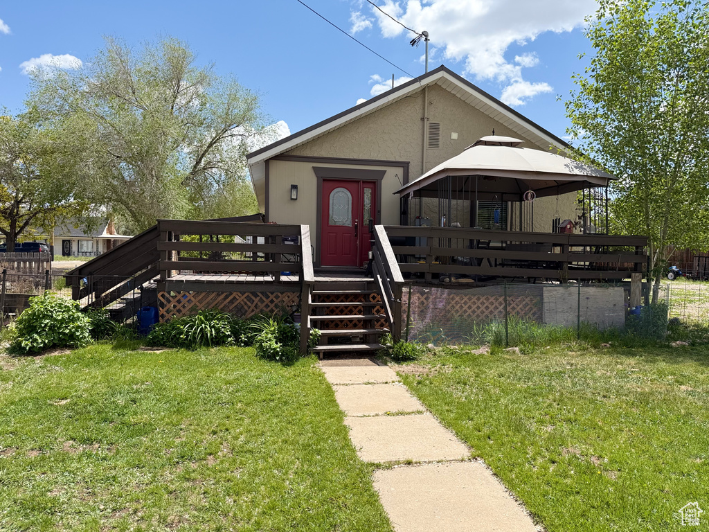 View of front facade with stairway, a wooden deck, a gazebo, and a front lawn