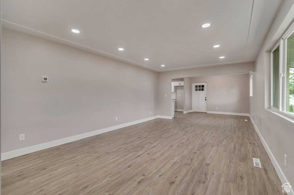 Empty room featuring light wood-type flooring, recessed lighting, and baseboards