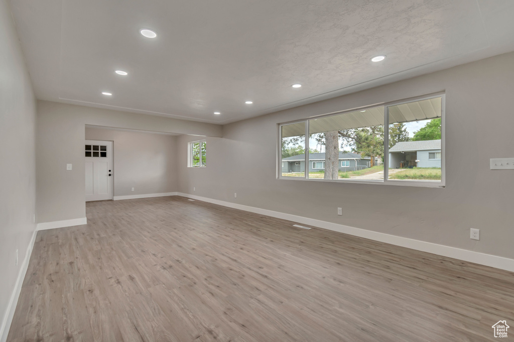 Spare room with recessed lighting, baseboards, and wood finished floors