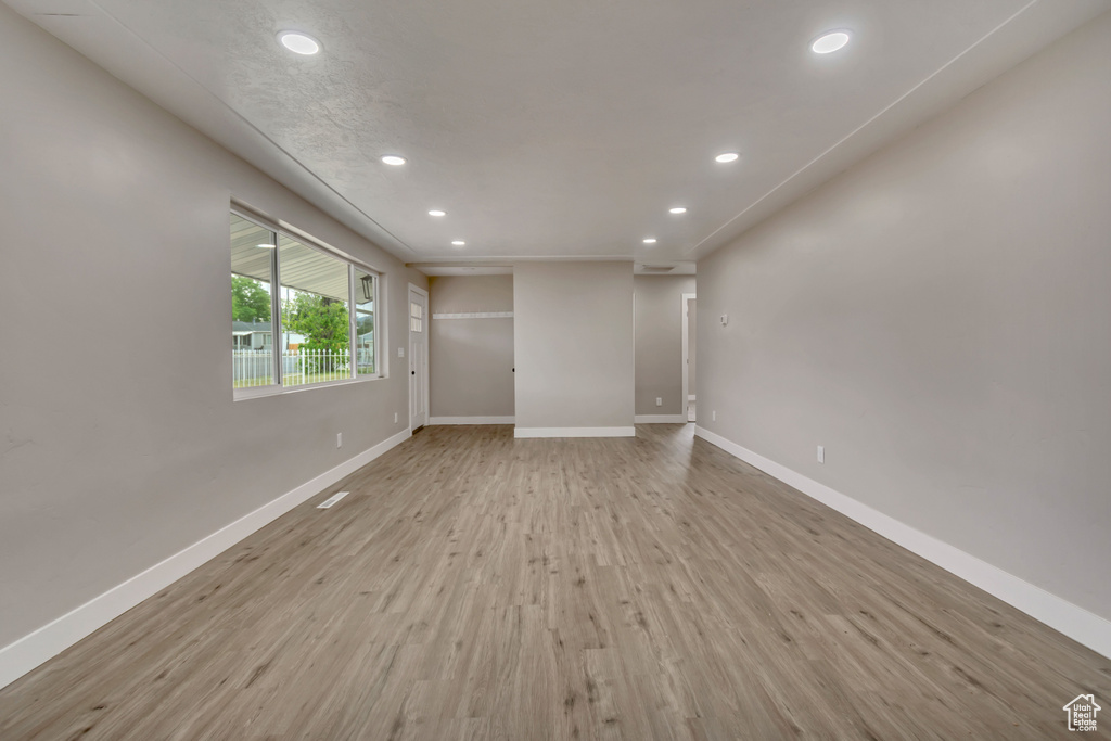 Unfurnished room with recessed lighting, light wood-type flooring, and baseboards