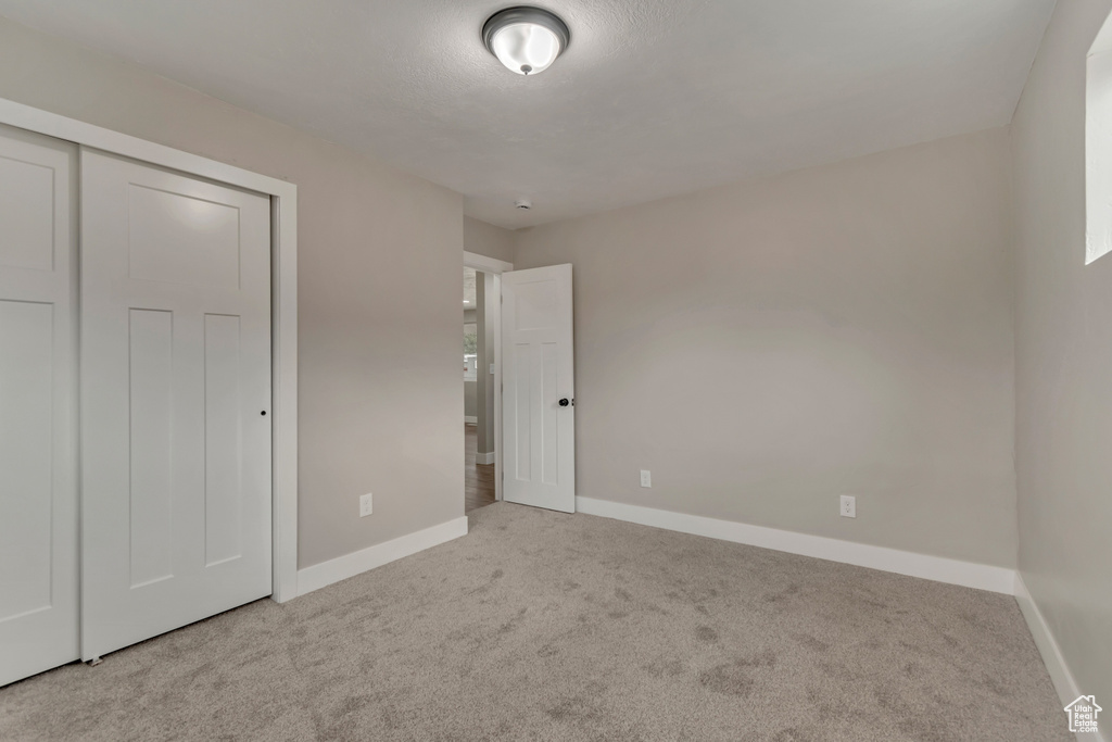 Unfurnished bedroom with baseboards, carpet flooring, and a closet