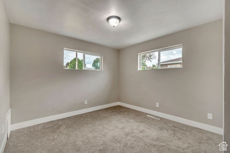 Unfurnished room featuring carpet floors and baseboards